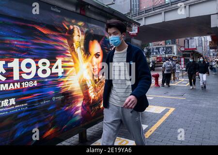 Hongkong, China. Dezember 2020. Ein Fußgänger geht an einer Werbetafel von Warner Bros Official Site und DC Comics Charakter Wonder Woman 1984 Film in Hong Kong vorbei. Kredit: Budrul Chukrut/SOPA Images/ZUMA Wire/Alamy Live Nachrichten Stockfoto