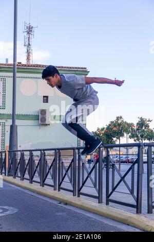 Aktiver Latino junger Mann springt in Aktion. Extreme sportliche Aktivität, Parkour Outdoor Free Running oder gesundes Lifestyle-Konzept Stockfoto