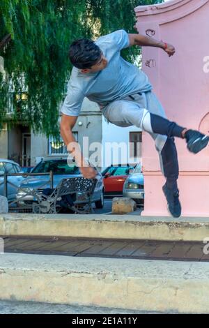 Aktiver Latino junger Mann springt in Aktion. Extreme sportliche Aktivität, Parkour Outdoor Free Running oder gesundes Lifestyle-Konzept Stockfoto