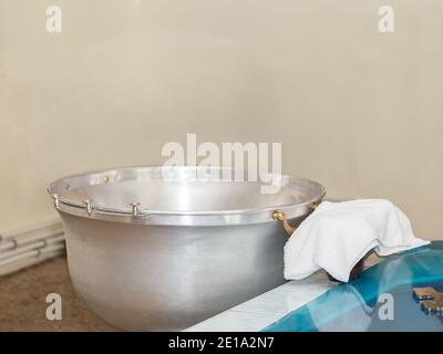 Schrift mit Wasser für die Taufe in der Orthodoxie. Christliches Ritual der Weihe Christi. Stockfoto