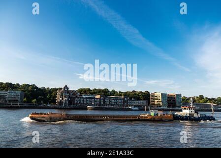 Hamburg, Deutschland - 22. August 2019: Schlepper mit Frachtschiff im Hafen an der Elbe in Hamburg, Deutschland Stockfoto