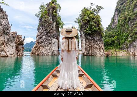 Junge weibliche Touristin in Hut bei Longtail Boat Erkundung Türkis Cheow Lan Lake Stockfoto