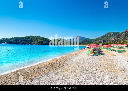 Strand mit Sonnenschirmen und Liegestühlen am Oludeniz, Türkische Riviera, Türkei Stockfoto