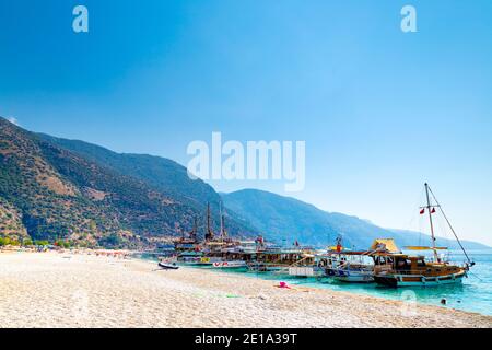 Touristenboote und türkische Gulets am Strand in Oludeniz, Türkische Riviera, Türkei Stockfoto