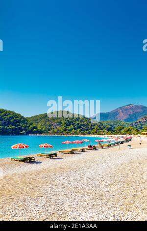 Strand mit Sonnenschirmen und Liegestühlen am Oludeniz, Türkische Riviera, Türkei Stockfoto