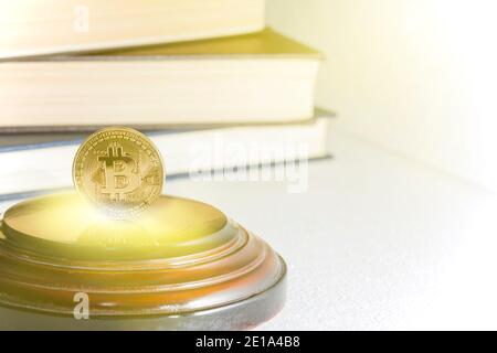 Einzelne Bitcoin Münze oder Symbol steht in scharfem Fokus auf einer reflektierenden Oberfläche mit Gold gefärbt. Stockfoto