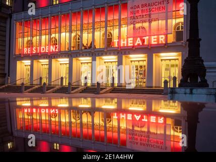 München, Deutschland. Januar 2021. Die beleuchtete façade des Residenztheaters im Stadtzentrum, die aufgrund der Corona-Maßnahmen geschlossen wurde, spiegelt sich auf einem Autodach wider. Kredit: Peter Kneffel/dpa/Alamy Live Nachrichten Stockfoto