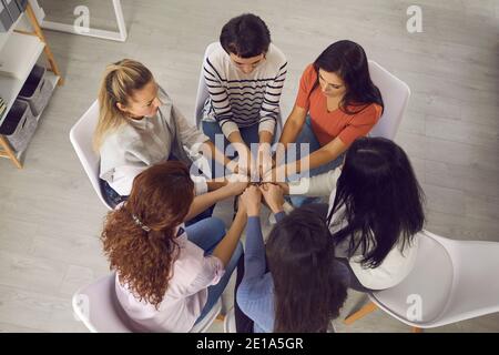 Frauen sitzen im Kreis und halten die Hände in der Therapie-Sitzung Oder Gruppenbesprechung unterstützen Stockfoto