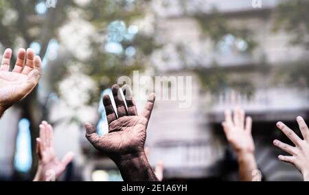 Multikulturelle Hände, die in der Luft erhoben werden und bei einer Demonstration auf der Straße um Freiheit bitten.Offene Handfläche mit schwarzer Hand und weißen Händen. Stoppen Sie Rassismus. Stop Rep Stockfoto