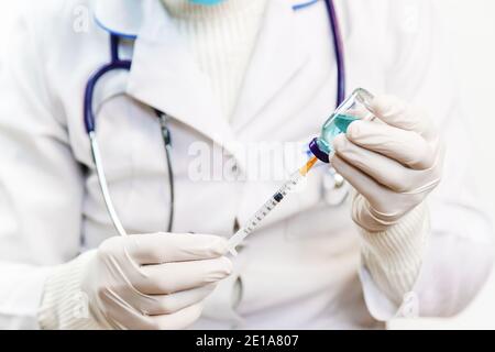 Doktor Füll Spritze mit Medikamenten, Nahaufnahme. Impfungen und Impfungen. Selektiver Fokus. Impfstoff. Stockfoto