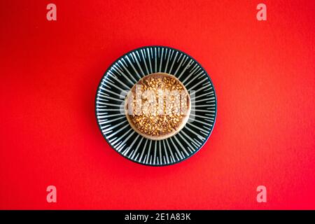 Eine einzige traditionelle Weihnachten Polvoron süß auf einer kleinen Keramik Schale Stockfoto