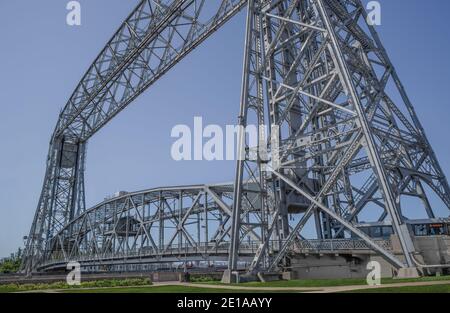 Lift Bridge: Vertikale Gleise erlauben dem mittleren Teil einer großen Brücke, sich nach oben zu heben, was hohen Booten Durchgang durch einen Hafen in Duluth, MN, gibt. Stockfoto