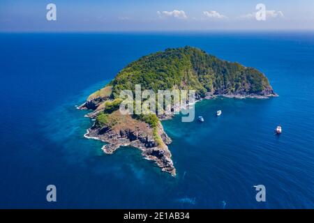 Luftdrohnenansicht von Booten um eine wunderschöne, abgelegene tropische Insel in einem blauen Ozean Stockfoto