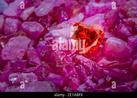 Herzförmiger rubinroter Diamant auf rohem Rubin Edelstein auf Rohe himmelblaue Edelsteine Stockfoto