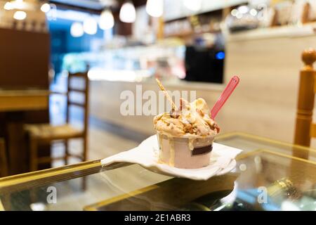 Natürliches Eis in einer Tasse schmilzt auf einem Glas Tisch in einem Café Stockfoto