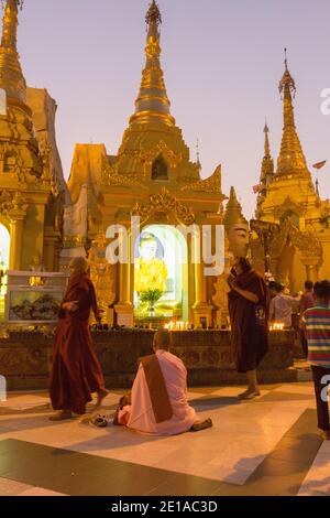 Am frühen Abend beten eifrige Anhänger in der Shwedagon Pagode bei Dämmerung Stockfoto