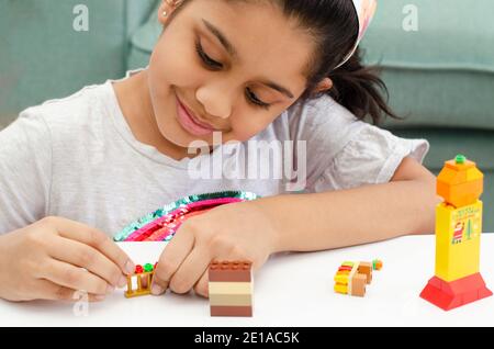 Portrait eines niedlichen kleinen indischen Mädchen mit bunten Spielzeug Bausteine spielen und Spaß haben. Stockfoto