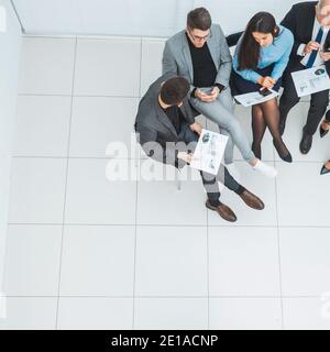 Von oben. Gruppe von Mitarbeitern, die in einem Konferenzraum sitzen. Stockfoto