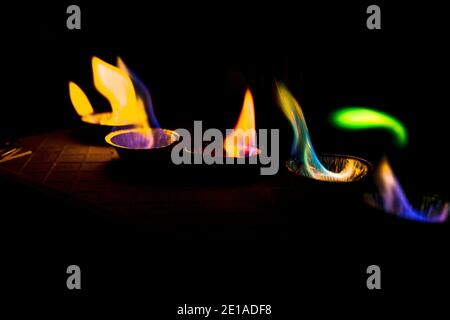 Chemisches Experiment mit Feuer. Mehrfarbige Flammen im Dunkeln. Stockfoto