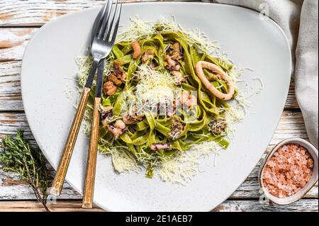 Grüne Fettuccine Spinat Pasta mit Meeresfrüchten in Sahne-Sauce. Weißer Hintergrund. Draufsicht Stockfoto