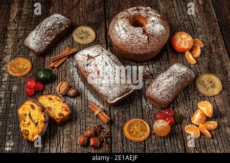 Weihnachtliche Komposition aus getrockneten Früchten und Stollen, mit Mandarine, auf einem Holztisch mit Struktur, mit Gewürzen. Zu Weihnachten. Stockfoto