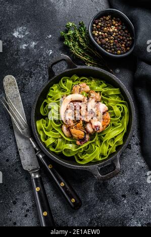 Fettuccine Spinat Pasta mit Meeresfrüchten in Sahne-Sauce. Schwarzer Hintergrund. Draufsicht Stockfoto