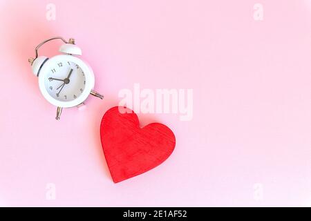 Zeit für die Liebe - Wecker und Herzen auf Holz Und blauer Hintergrund Stockfoto
