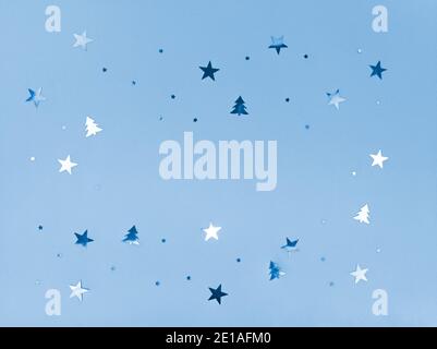 Konfetti Sterne und Bäume funkeln auf blauem Hintergrund. Stockfoto