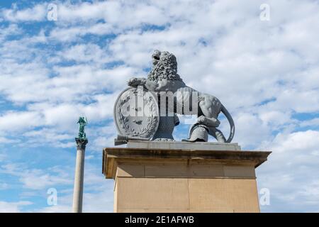 Eine Löwenstatue in Stuttgart, Deutschland. Der Löwe setzt sich auf eine Spalte in der Schlossplatz. Stockfoto