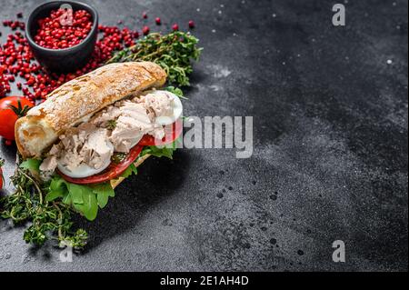 Ciabatta-Sandwich mit Leberpastete, Rucola, Tomate, Ei und Kräutern. Schwarzer Hintergrund. Draufsicht. Speicherplatz kopieren Stockfoto