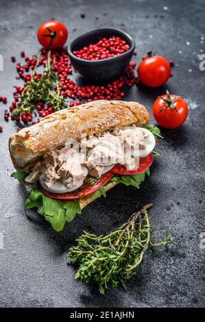 Sandwich mit Leberpastete, Rucola, Tomate, Ei und Kräutern. Schwarzer Hintergrund. Draufsicht. Stockfoto