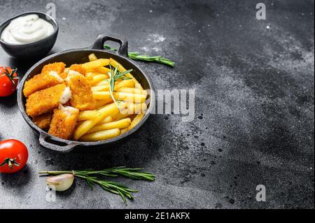 Fish and Chips, britisches Fast Food mit Tatarsauce. Schwarzer Hintergrund. Draufsicht. Speicherplatz kopieren Stockfoto