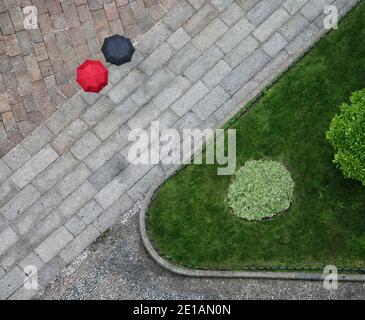 Blick von oben auf die Straßengeometrie mit schwarz und rot Regenschirme Stockfoto