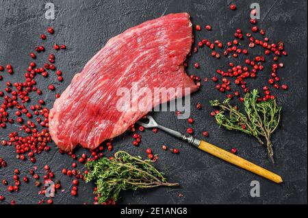 Rohes Flankensteak mit Rosmarin und rosa Salz. Frisches Marmor Rindfleisch Fleisch schwarz Angus. Schwarzer Hintergrund. Draufsicht Stockfoto