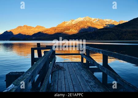 Kleiner einsamer Steg am schönen Schweizer See, im Hintergrund die Berge. Im Herbst. Stockfoto