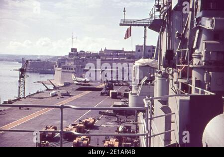 Das Flugdeck der HMS Ark Royal in Valletta Grand Harbour, Valletta, Malta. Auf dem Deck befinden sich zwei Supermarine Scimitar-Kampfjets des NAS. Ein Mitglied der Crew schaut aus dem Überbau. November 1960. Stockfoto