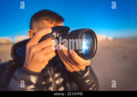 Nahaufnahme eines professionellen Fotografen, der mit seiner Kamera fotografiert Stockfoto