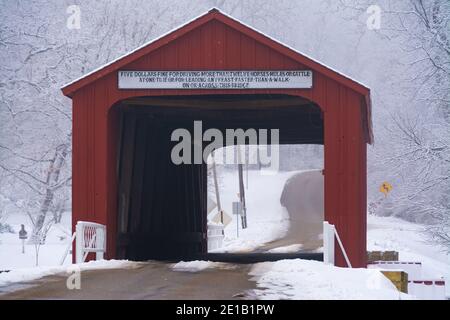 Red Covered Bridge im ländlichen Illinois an einem nebligen Wintermorgen. Princeton, Illinois. Stockfoto