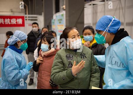 (210106) -- PEKING, 6. Januar 2021 (Xinhua) -- EINE Frau konsultiert einen Mitarbeiter, während sie darauf wartet, einen Schuss COVID-19-Impfstoff an einer Impfstelle im Bezirk Chaoyang, Peking, Hauptstadt von China, zu erhalten, 5. Januar 2021. Zusammen mit mehr als 70 seiner Kollegen aus der Lebensmittelverarbeitung bestieg Herr Wu (dessen Vorname zum Schutz der Privatsphäre ausgelassen wird), 40, einen Shuttle-Bus, der sie am Dienstag gegen 13 Uhr zu einer Impfstelle bringen würde. Wu, der für ein Unternehmen arbeitet, das in der Konditorei, Bäckerei und Kühlkette Transport beteiligt ist, sagte alle seine Kollegen außer denen mit ungeeigneten Physi Stockfoto