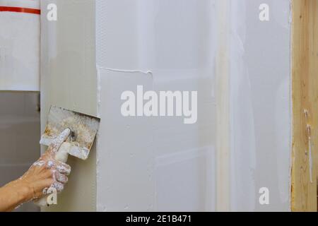 Baumeister legt Gips an die Wand Hand hält einen Spachtel Mit der Baureparatur in der Wand arbeitet der Kitt der Veredelung Stockfoto