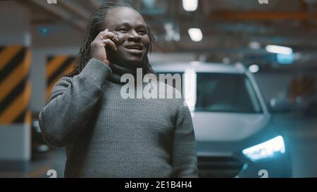 Aufgeregt afroamerikanischen schwarzen Mann mit Telefongespräch in der Tiefgarage. Hochwertige Fotos Stockfoto