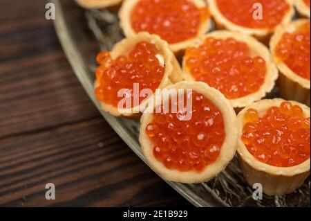 Tartlets mit Lachskaviar auf einer Platte. Nahaufnahme, selektiver Fokus Stockfoto