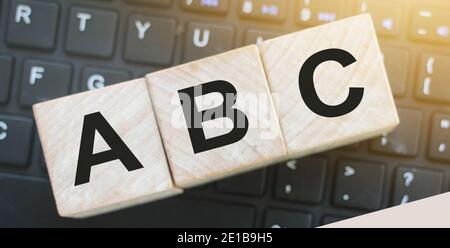 Alphabet Holzblöcke ABC auf Computer-Tastatur. Computerkompetenz Bildungskonzept Stockfoto