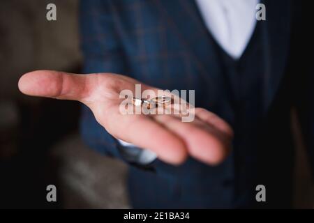 Eine goldene Hochzeit liegt in der Hand des Bräutigams Stockfoto