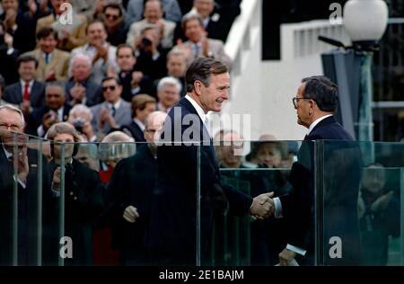 Washington DC, USA, 20. Januar 1989 der 41. Designierte Präsident des US-Vizepräsidenten George H.W.Bush schüttelt die Hände mit Senator Ted Stevens (R-AK), nachdem Stevens ihn zu Beginn des Antrittsverfahrens an der Westfront des US-Kapitols vorstellt Stockfoto