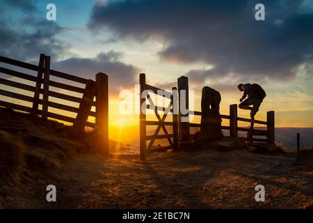 Peak District Sonnenuntergang Sonnenaufgang mit Kletterer Wanderer am Mam Tor Winnats Pass Tor Klettern über Zaun Stil auf Pfad atemberaubend Landschaft Wolken Derbyshire Stockfoto