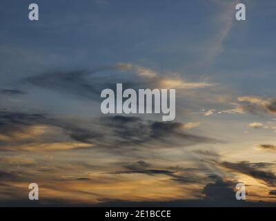 Cumulus Wolke mit Sonnenstrahl auf schönen blauen Himmel bei Sonnenuntergang, der Horizont wird orange und Gold Farbe in der Nacht, flauschige Wolken Formationen Stockfoto