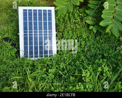 Kleine tragbare Solarzellen-Panel auf dem Rasen, saubere Energie für die Stromerzeugung im Haus, mit alternativen Technologien auf grünen Rasen Stockfoto