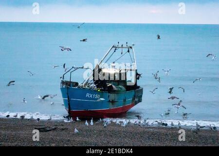 Hastings, East Sussex, Großbritannien. 6th. Januar 2020. Hastings Fischerboot Landung bei Sonnenaufgang an einem regnerischen Morgen mit nur einem kurzen Blick auf die Sonne. CClarke/Alamy Live News Stockfoto