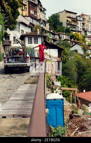 4. September 2020, Veliko Tarnovo, Bulgarien. Mann Reinigung mobile chemische öffentliche Toilette in der Straße Selektive Fokus Stockfoto